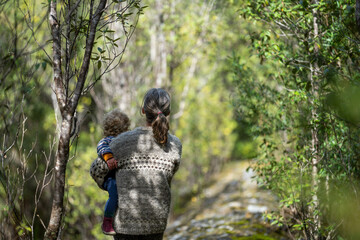 Mother with baby in a carrier on her chest on a hike, taking a bush walk in Summer in a national park in Sydney, nsw, Australia - obrazy, fototapety, plakaty