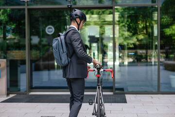 Young man in a suit commuting to work on electric scooter