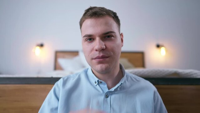 Video chat POV of intelligent confident young man talking gesturing in slow motion looking at camera. Front view portrait of Caucasian freelancer convincing persuading online in home office