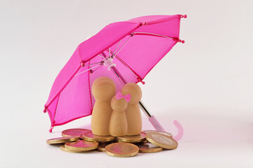 Family and pile of coins under umbrella - Concept of family and financial protection