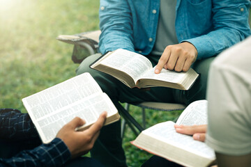 Christian group read and studied the bible at the park and prayed together. sharing the gospel with a friend. Holy Bible study reading together on Sunday. Study the Word Of God With Friends. Education - obrazy, fototapety, plakaty