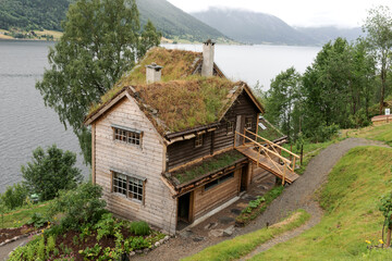 Fototapeta na wymiar Traditional old wooden house in the mountains. Grass on the roof. Norway