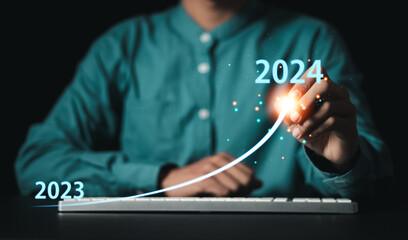 Start up business on new year concept. Businessman analyzes corporate rising arrow graph from 2023...