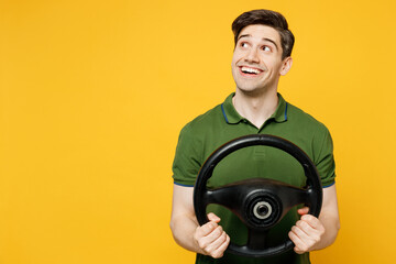 Young dreamful wistful fun minded man he wears green t-shirt casual clothes hold steering wheel...