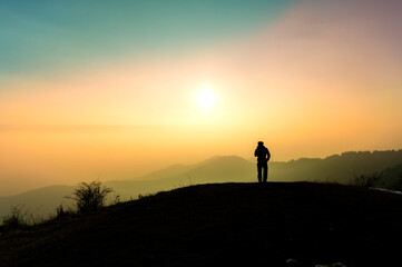 Fototapeta premium Person backlit, looking towards the sky. Contemplation, solitude, single. 