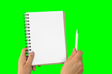 Female Hand Holding Notepad with blank Page Isolated On Green Background. Close Up. Chroma Key Screen. Woman's Hand with Empty Card Paper MockUp. Advertisement gesture. Notebook Mock Up. Greenscreen