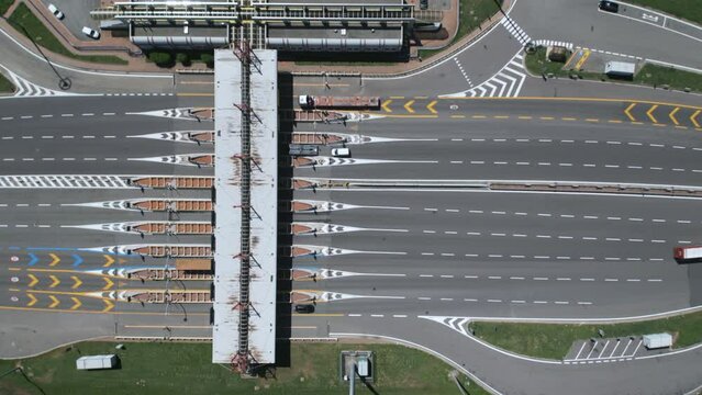 Aerial view from above  of an Italian highway toll booth. Time-lapse cars queuing up to pay the highway toll and automatic paying lanes.