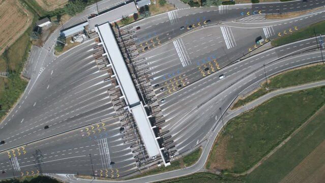 Aerial view from above  of an Italian highway toll booth. Time-lapse cars queuing up to pay the highway toll and automatic paying lanes.