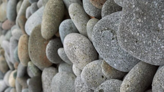 Perfect brown grey speckled pebble rocks slow zoom out zen soothing feeling, vertical Looc Beach Surigao Philippines