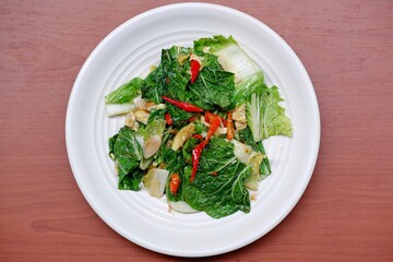Stir fry Chinese cabbage, stir fry Napa cabbage, tumis sawi putih  served on white plate on isolated background. Stir fried Chinese cabbage, stir fried Napa cabbage