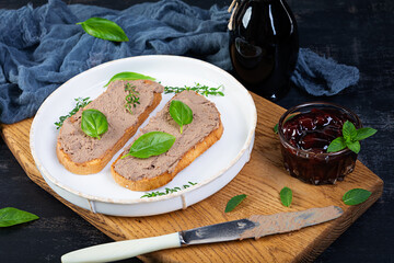 Grilled sandwich with pate with chicken liver and olives on dark background