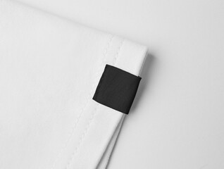 Blank black colour clothing label on white t shirt sleeve