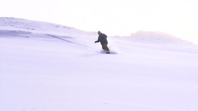 Colorado cinematic winter wonderland super slow motion male man professional snowboarder snowboarding fresh snow powder top of Vail Pass Colorado epic turns slash dreamy misty snow flakes