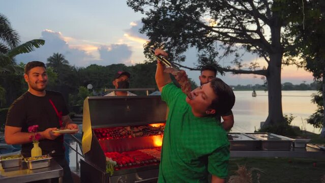 Latin mexican friends at garden barbecue sunset party lake eat direct from grill fire meat steak fun enjoy manhood brotherhood just mand funny