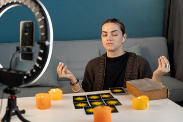 Fortune teller blogger with tarot cards to prediction future uses ring lamp and smartphone....