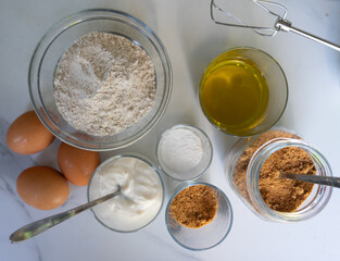 Fototapeta na wymiar Ingredients to make a cake with whole wheat flour, yeast, olive oil, yogurt and eggs
