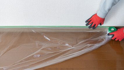 養生資材・a protective coating｜マスカーで床を保護する作業員