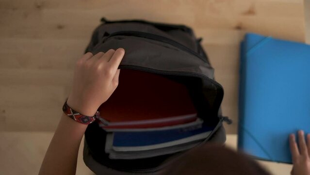 A boy prepares his school backpack  for the return to school