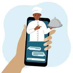 Online food shopping on mobile phone or fast food delivery order. The cook holds a tray with a lid or a plate with a cloche.