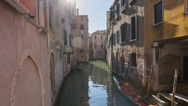 Canal, bridges and old historical buildings of Venice early in the morning, without people. Camera moves along the bridge over canal, gimbal shot. Typical Venetian canal with gondolas early in the