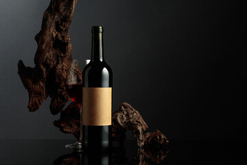 Red wine and old weathered snag on a black background.