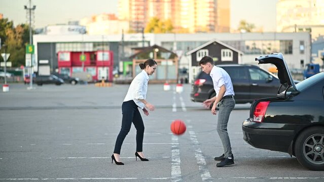 Young Office Workers Or Students Playing Basketball In A Supermarket Parking Lot Using The Car Trunk As A Hoop. Slowmotion