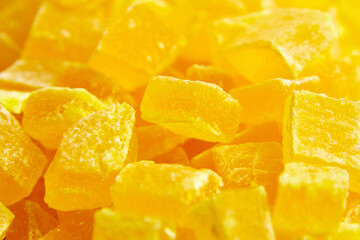 Diced mango dried fruits texture background. Dehydrated mango chips dices, sweet food closeup. The softness of dehydrated mango against the candied coating offers a delightful contrast.