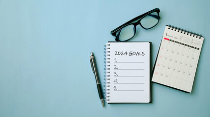 2024 New Year goal, plan, and action concepts. 2024 goals Text on Note Pad with calendar, glasses on the table.New Year's resolutions plan.Happy New Year theme, top view, copy space. - obrazy, fototapety, plakaty