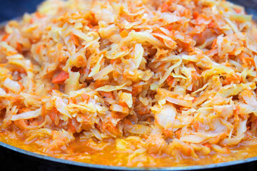 Stewed cabbage in a frying pan, bigos. Country style dinner cooked on fire, barbecue