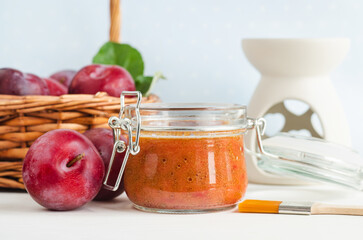 Homemade plum face mask in a glass jar and make-up brush. Natural beauty treatment and spa recipe.