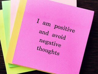 Pink note with message I AM POSITIVE AND AVOID NEGATIVE THOUGHTS, concept of affirmation message or...