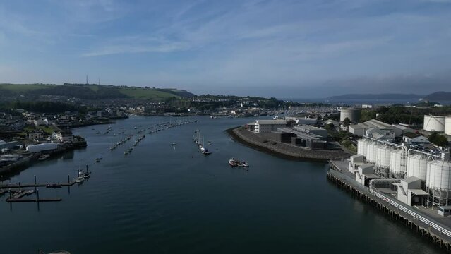 Plymouth, Devon, England: DRONE VIEWS: The River Plym: Riverfront warehouses & factories including a cement factory (white silos); Moored yachts; Plymouth Sound and the sea in the distance (right).