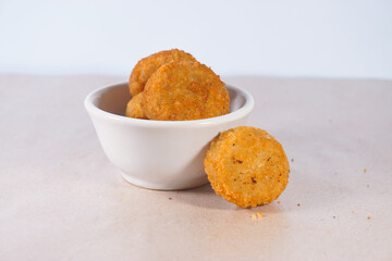 Circle chicken nuggets in a wooden container on a white background. Nugget Lingkaran