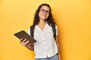 Student holding a tablet, glasses, backpack on, dreaming of achieving goals and purposes