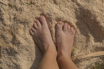 Child's feet standing on sawdust. Sensory perception, sensitivity and flat feet problem in children