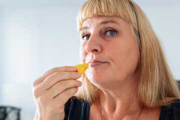 Portrait attractive blonde middle-aged woman taking care of facial skin, lips