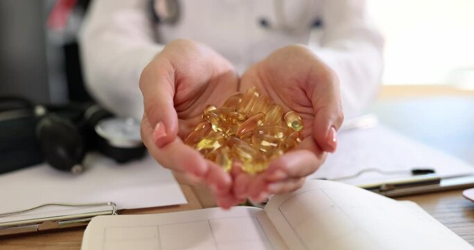 Doctor holding many omega 3 capsules in hands in clinic closeup 4k movie slow motion. Treatment with dietary supplements concept