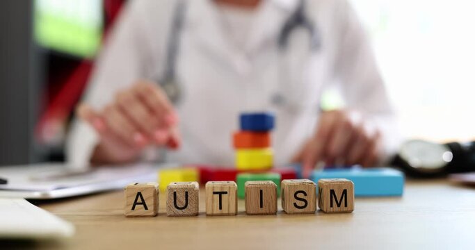 Word autism is written on background of doctor in clinic closeup 4k movie slow motion. Mental illness in children concept