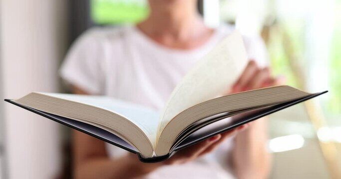 Woman reading book and flipping through pages closeup 4k movie slow motion. Hobby reading concept