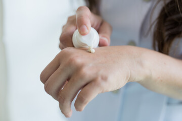 Close-up of a woman applying a protective cream on her hands.protection of the skin of the hands in the cold season