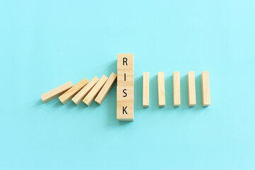 Wooden cubes with the text risk, stopping the domino effect. success and challenge concept