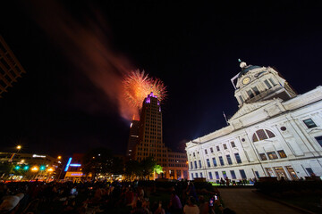 Naklejka premium Orange and gold 4th of July fireworks downtown Fort Wayne courthouse and Lincoln Tower