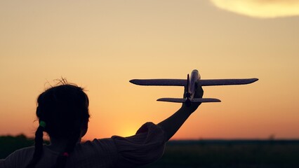 Kid, become an airplane pilot, Happy girl child runs with toy plane sunset. Child dream to fly....