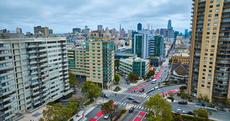 Aerial city streets of Geary Blvd and Starr King Way with distant San Francisco skyscrapers