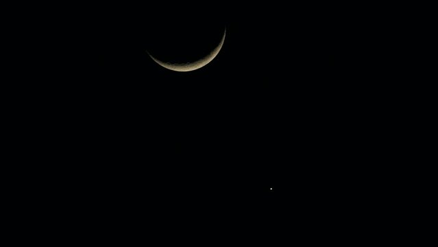 A new moon and a star are visible in the sky