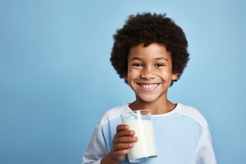 African American little boy happily drinking milk isolated on blue background - obrazy, fototapety, plakaty