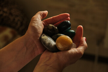 Woman Holding a different natural magic massage stones with both hands