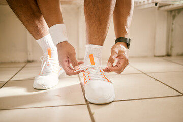 Locker room, fitness and person tie shoes for training, exercise and workout for practice or match. Sports, gym and closeup of athlete tying laces for performance, wellness and ready for competition