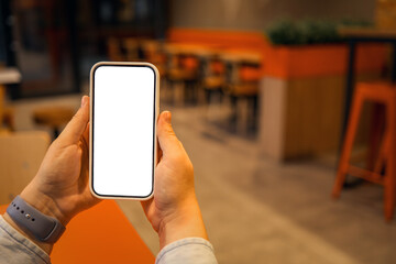 Phone in hand against the background of a cafe