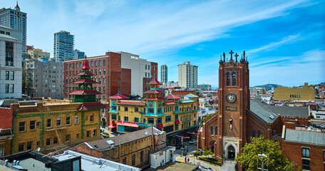 Aerial of colorful Chinatown buildings and church on blue sky day with partial clouds